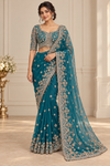 AI-generated model wearing teal beadwork net saree